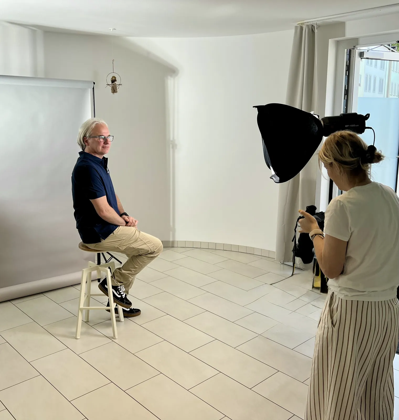 Photographer taking a team member's portrait, September 2025