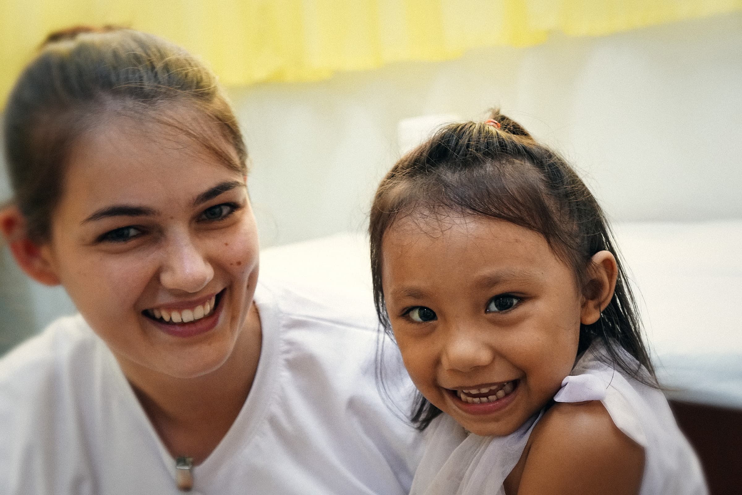 Ehrenamtliche Helferin mit einem Kind während eines medizinischen Einsatzes auf den Philippinen