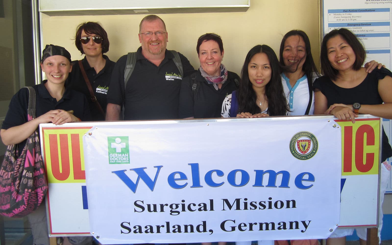 The team behind a welcome banner for Surgical Mission Saarland